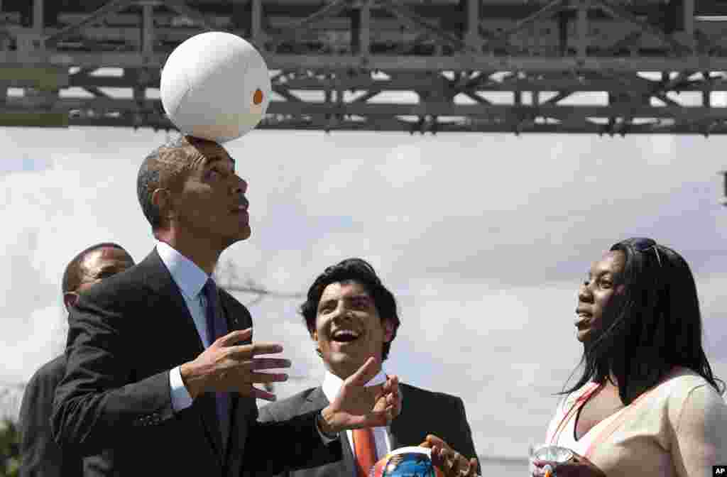 U.S. President Barack Obama demonstrates &quot;the Soccket Ball,&quot; which uses kinetic energy to provide power to charge a cell phone or power a light, during an event at the Ubungo power plant to promote energy innovation in Dar Es Salaam, Tanzania.