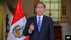 In this photo provided by the Peruvian government, President Martin Vizcarra delivers a national address from the government palace in Lima, Sept. 16, 2018.