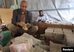 FILE - A money changer waits for customers at a local bureau where $100 U.S. dollars exchange for 750,000 Somaliland shillings in Hargeysa.