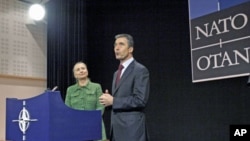 U.S. Secretary of State Hillary Clinton (L) and NATO Secretary General Anders Fogh Rasmussen talks following a NATO foreign ministers meeting at the Alliance headquarters in Brussels, December 8, 2011.
