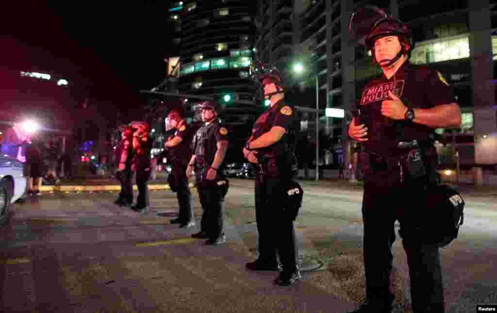 Police officers stand guard during a protest against U.S. President-elect Donald Trump in Miami, Florida, Nov. 11, 2016. 