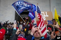 FILE - Insurrections loyal to President Donald Trump riot outside the Capitol, Jan. 6, 2021, in Washington.