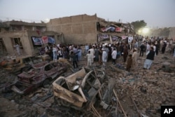 Afghan civil society members light candles during a vigil for victims of Friday's attacks, while gathering at the site of a truck bomb attack in Kabul, Afghanistan, Aug. 8, 2015.