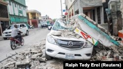 Sebuah mobil rusak di bawah puing-puing setelah gempa berkekuatan 7,2 di Les Cayes, Haiti 15 Agustus 2021. (Foto: REUTERS/Ralph Tedy Erol)