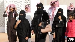 FILE - A group of Saudi women and men are seen walking in Rumah, 160 kilometers east of Riyadh, Saudi Arabia, Jan. 19, 2018.