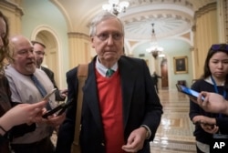 Senate Majority Leader Mitch McConnell, R-Ky., is met by reporters as he arrives at the Capitol on the first morning of a partial government shutdown, as Democratic lawmakers, and some Republicans, are at odds with President Donald Trump on spending.