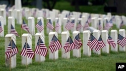 Американские флаги рядом с могилами ветеранов в преддверии Дня поминовения на Национальном кладбище Краун-Хилл, Индианаполис, 29 мая 2021 года