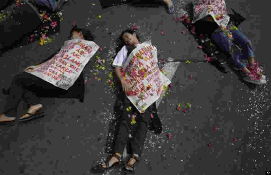 Filipino women activists stage a play to symbolize human rights violations during a demonstration to mark the International Day of Action on Violence Against Women near the Malacanang presidential palace in Manila, Philippines, Friday Nov. 25, 2011. The w