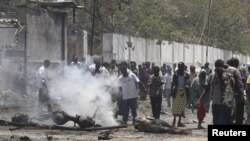 Residents gather at the scene of a suicide attack along a street in Somalia's capital Mogadishu October 4, 2011.