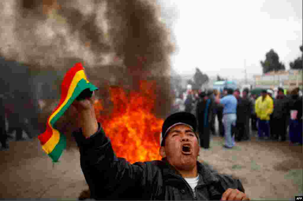 Dec. 29: Holding up a Bolivian flag in front of a bonfire, a demonstrator shouted slogans against increases in the price of fuel in El Alto. Bolivians were protesting a 73 percent jump in gasoline prices and and 83 percent rise in the price of diesel fuel
