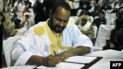 FILE - Sidi Brahim Ould Sidati, a member of the Arab Movement of Azawad, signs the peace accord on behalf of the Coordination of Azawad Movements in Bamako, Mali, June 20, 2015.