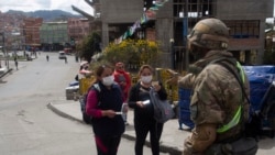 Un soldado en La Paz, Bolivia, detiene a unas mujeres para revisar sus documentos en medio de la cuarentena impuesta por el gobierno.