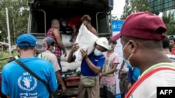 ရန်ကုန်မြို့ ဆင်ခြေဖုံးတနေရာမှာ ကမ္ဘာ့စားနပ်ရိက္ခာအဖွဲ့ WFP က လှူဒါန်းတဲ့ ဆန်အိတ်တွေရယူဖို့ စောင့်ဆိုင်းနေသူများ (မေ ၂၁၊ ၂၀၂၁)