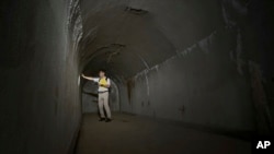 In this June 23, 2015 photo, Takeshi Akuzawa, assistant headmaster of Keio Senior High School, speaks on chief commander’s room at underground tunnels that Japan’s Imperial Navy once used as secret headquarters underneath of Hiyoshi Campus of Keio University in Yokohama.