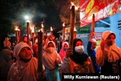 Anak-anak membawa obor untuk merayakan Idulfitri, menandai akhir bulan suci Ramadhan, di tengah pandemi COVID-19 di Jakarta, 12 Mei 2021. (Foto: REUTERS/Willy Kurniawan)