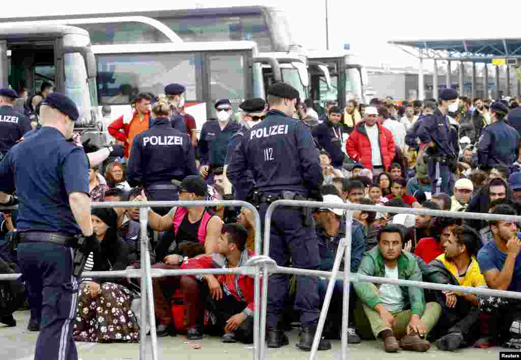 Migrants wait to board busses in Nickelsdorf, Austria. Thousands of migrants walked unhindered across the border into Austria from Hungary, where the frontier was kept open despite Germany&#39;s sudden reintroduction of checks.