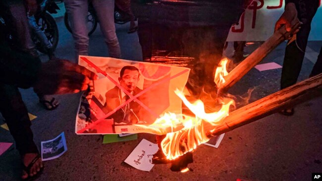 Protesters burn an image of Cambodian Prime Minister Hun Sen during a rally against the upcoming visit to Myanmar by the Cambodian leader, on Jan. 3, 2022, in Mandalay, Myanmar.