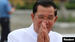 FILE - Cambodia's Prime Minister Hun Sen (R) and his wife Bun Rany arrive at the Royal Palace during commemorations for the second anniversary of late king Norodom Sihanouk's death, in Phnom Penh.