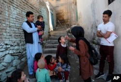 FILE - A health worker gives a polio vaccination to a child in the old part of Kabul, Afghanistan, March 29, 2021.