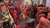 Veiled Hindu women playfully beat men with bamboo sticks as they take part in "Lathmar Holi" celebrations in the town of Nandgaon, Uttar Pradesh, India, March 9, 2025.