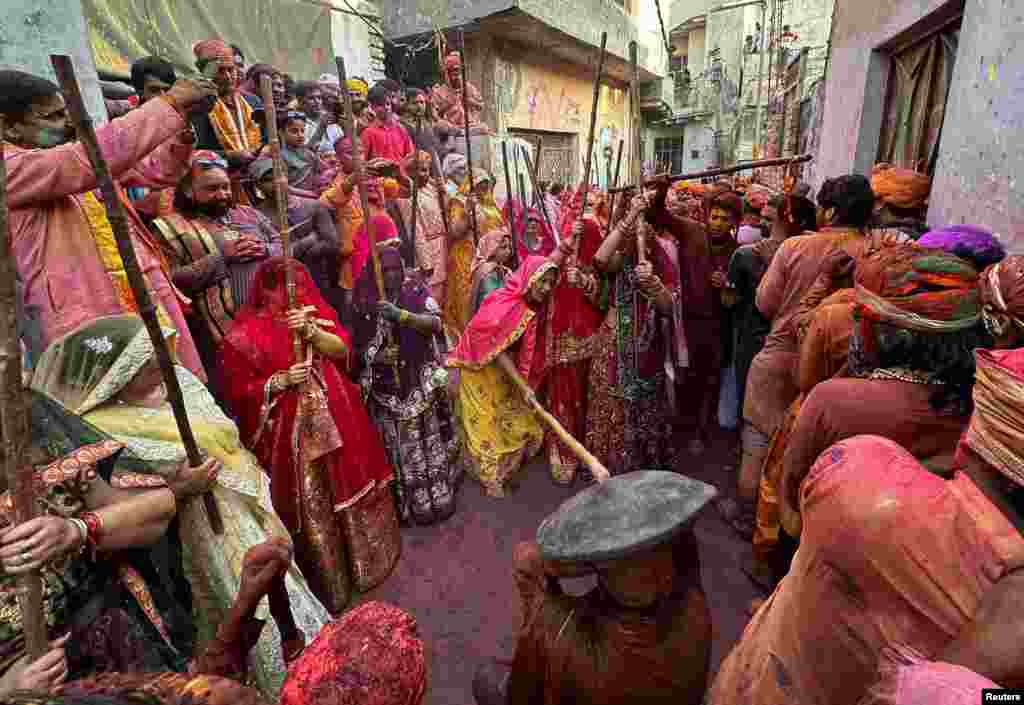 Veiled Hindu women playfully beat men with bamboo sticks as they take part in &quot;Lathmar Holi&quot; celebrations in the town of Nandgaon, Uttar Pradesh, India.