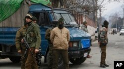 Indian policemen guard as a convoy of New Delhi-based diplomats passes through Srinagar, Indian controlled Kashmir, Jan. 9, 2020.