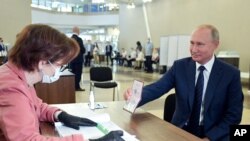  블라디미르 푸틴 러시아 대통려이 1일 모스크바의 투표소에 도착해 여권을 보이고 있다. 
