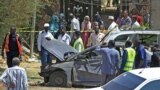 Sudanese rescue teams and security forces gather next to damaged vehicles at the site of an assassination attempt against Sudan's Prime Minister Abdalla Hamdok, who survived the attack with explosives unharmed, in the capital Khartoum on March 9, 2020.