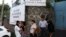 Un grupo de personas esperan fuera de la Dirección de Atención al Migrante en San Salvador, El Salvador, lugar al que llegan los salvadoreños deportados por vía terrestre, especialmente desde México. Foto AP.