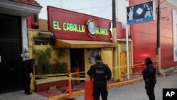 Police officers guard the scene outside a bar where more than 20 people died in an overnight attack, in Coatzacoalcos, Mexico, early Wednesday, Aug. 28, 2019. 