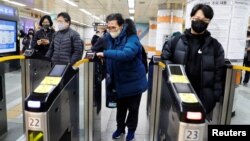 Park Gyung-sun passes a ticket barrier as he delivers a parcel in Seoul, South Korea, Feb. 8, 2023.