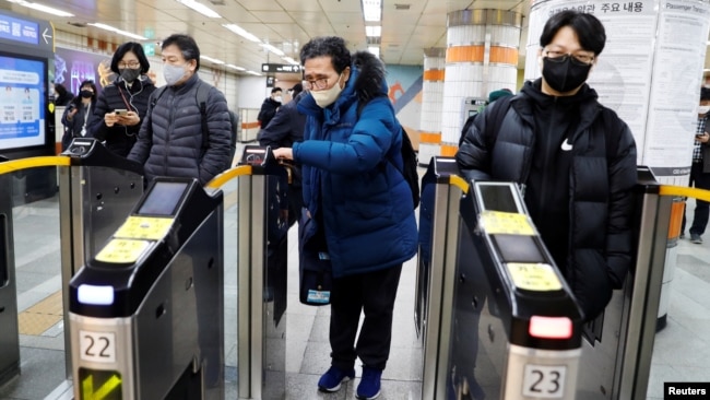 Park Gyung-sun passes a ticket barrier as he delivers a parcel in Seoul, South Korea, Feb. 8, 2023.