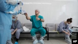 FILE - A doctor gets ready to put on protective gear before his shift at an intensive care unit of the Filatov City Clinical Hospital in Moscow, Russia, May 15, 2020. 