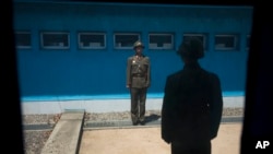 2011년 4월 17일 남북을 가르는 비무장지대(DMZ) 판문점 공동경비구역에서 북한군 초병들이 창문 너머로 경계 근무를 서고 있다.