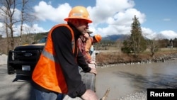 Nhân viên cứu hộ quan sát sông Stillaguamish gần khu vực nơi xảy ra vụ đất sạt lở gần Oso, Washington, ngày 23/4/2014.