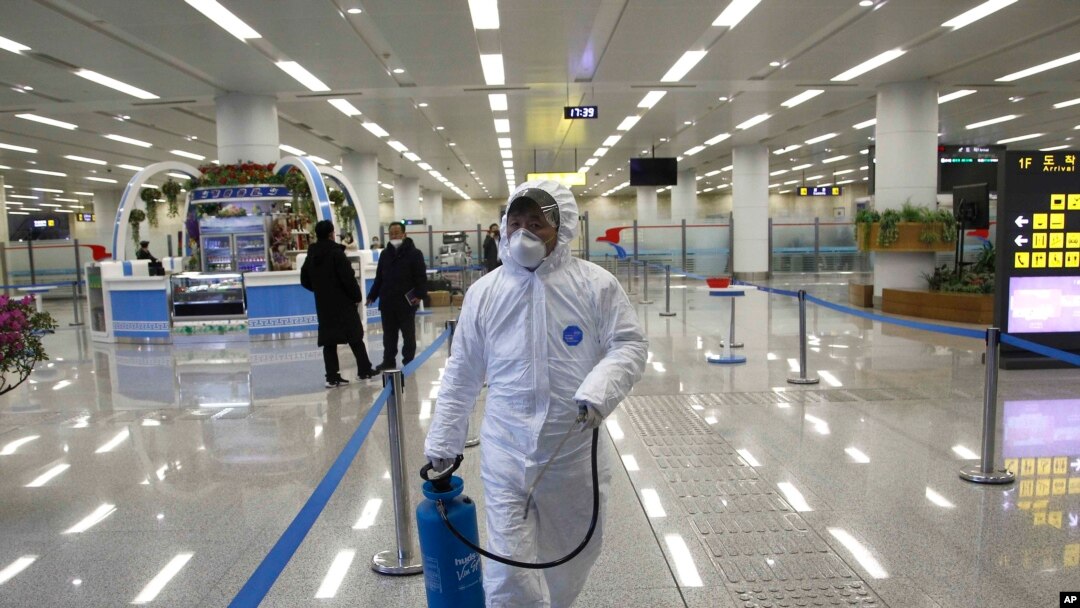 Petugas Korea Utara (mengenakan pakaian pelindung) menyemprotkan cairan desinfektan di Bandara Internasional Pyongyang , 1 Februari 2020. (Foto: dok).