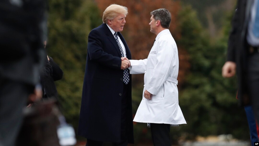 Presiden AS Donald Trump berjabat tangan dengan dokter pribadi presiden, Dr. Ronny Jackson, usai pemeriksaan medis di Walter Reed National Military Medical Center di Bethesda, Maryland, Jumat (12/1). 