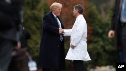 Presiden AS Donald Trump berjabat tangan dengan dokter pribadi presiden, Dr. Ronny Jackson, usai pemeriksaan medis di Walter Reed National Military Medical Center di Bethesda, Maryland, Jumat (12/1). 