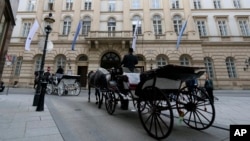 Dua kereta kuda di depan lokasi pertemuan para pejabat Rusia dan AS untuk membahas pengendalian senjata di Wina, Austria, Senin, 22 Juni 2020. (AP Foto / Ronald Zak)
