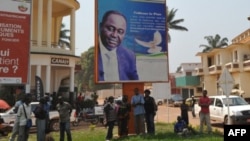 28일 중앙 아프리카 수도 방기 People stand under the poster of Central Africa Republic's President Francois Bozize in Bangui on December 28, 2012