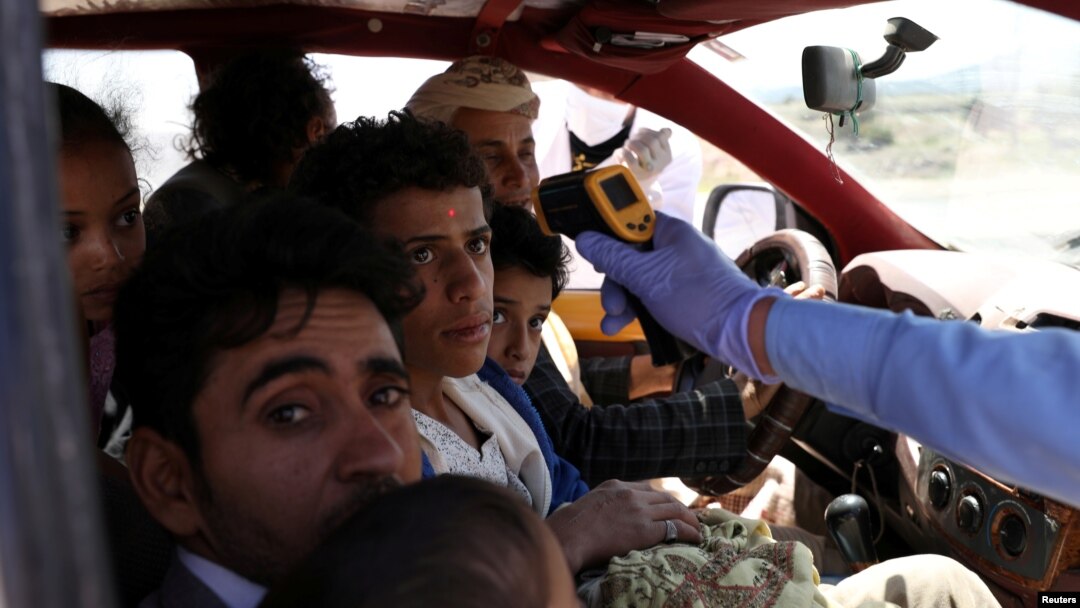 Seorang pekerja medis memeriksa suhu para penumpang di sebuah taksi di tengah kekhawatiran penyebaran wabah virus corona (Covid-19) di Sanaa, Yaman, 9 Mei 2020. (Foto: Reuters)