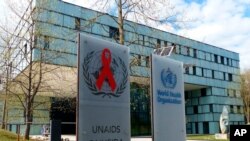 Sede de la Organización Mundial de la Salud en Ginebra, Suiza. En la entrada también se ve el logo de ONUSIDA. [Foto: Archivo- AP]