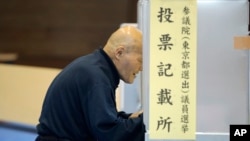 ຜູ້ລົງຄະແນນສຽງຄົນໜຶ່ງ ເລືອກເອົາຜູ້ລົງແຂ່ງຂັນ ກ່ອນ
ທີ່ຈະປ່ອນບັດລົງຄະແນນຂອງລາວ ໃນການເລືອກ
ຕັ້ງສະພາສູງຂອງ ຍີ່ປຸ່ນ Tokyo, July 10, 2016. 