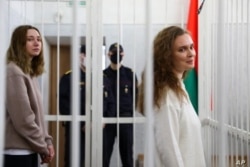 Las periodistas Katsiaryna Andreyeva, a la derecha, y Daria Chultsova dentro de la jaula de los acusados en una sala del tribunal en Minsk, Bielorrusia, el 18 de febrero de 2021.