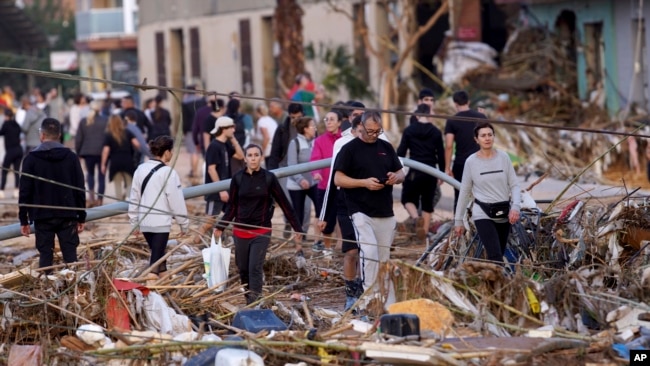 Los residentes caminan por una calle después de las inundaciones en Paiporta, cerca de Valencia, España, el miércoles 30 de octubre de 2024. (Foto AP/Alberto Saíz).