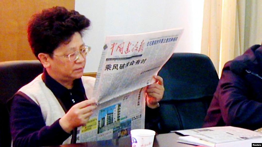 杨秀珠在浙江省温州市开会期间读报纸。（2001年12月29日资料照）