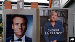 Poster kampanye pemilu capres berhaluan tengah, Emmanuel Macron, dan kandidat haluan kanan jauh, Marine Le Pen diperagakan di depan TPS dimana Marine Le Pen akan menggunakan hak suaranya di Henin Beaumont, sebelah utara Perancis, hari Sabtu, 6 Mei 2017 (foto: AP Photo/Francois Mori)