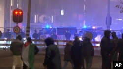 In this image taken from video, a group of pro-Palestinian protesters walk toward police line, with police vans driving in the background, near the soccer stadium in Amsterdam, Netherlands, Nov. 7, 2024. 