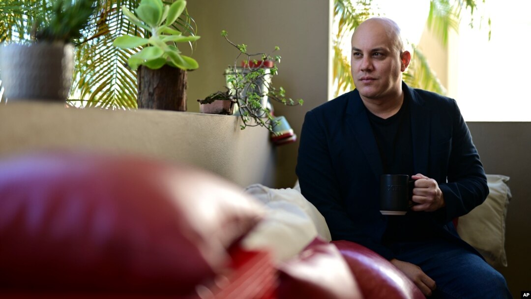 Omar Mediavilla, who urges his brother Jerick (Florida resident) to exercise the right to vote that the island's residents do not have, drinks a cup of coffee at his balcony in Toa Alta, Puerto Rico, Oct. 18, 2020. 