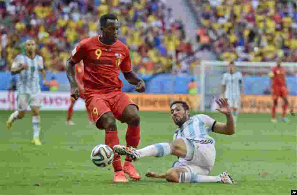 Argentina's Ezequiel Garay tackles Belgium's Romelu Lukaku during the World Cup quarterfinal soccer match between Argentina and Belgium at the Estadio Nacional in Brasilia, Brazil, Saturday, July 5, 2014. (AP Photo/Martin Meissner)